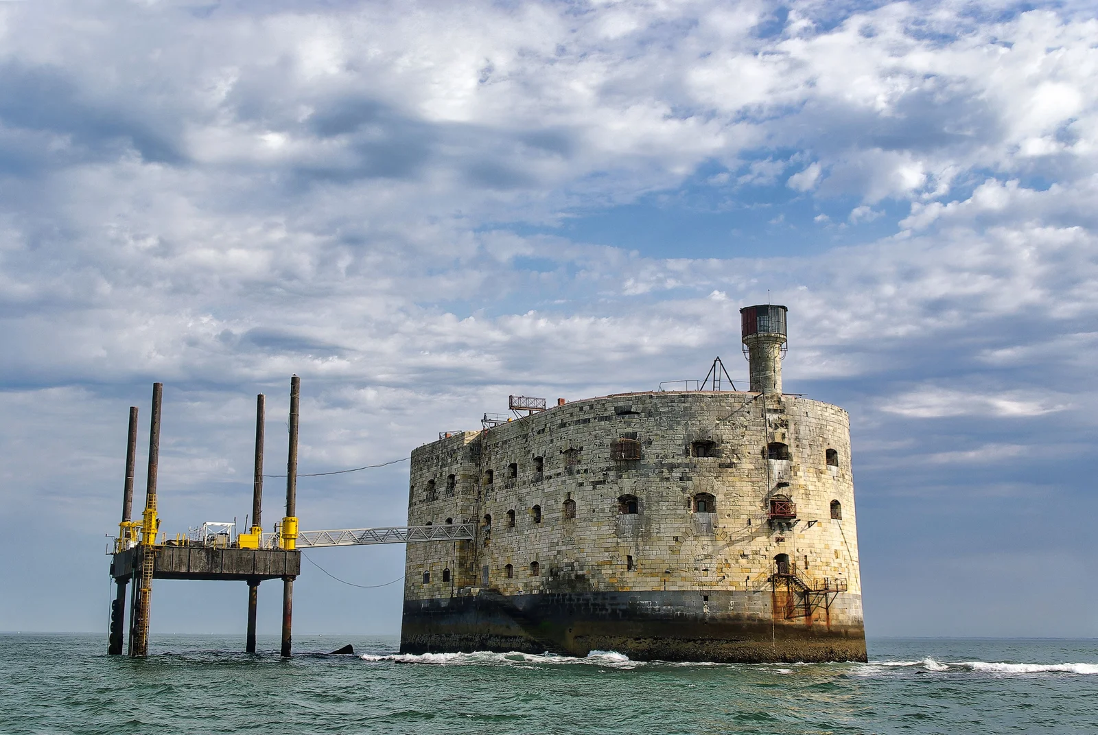 Fort de pierre isolé au milieu de la mer, vu depuis un bateau