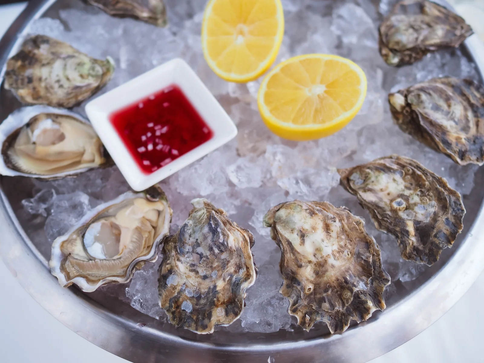 Huîtres ouvertes présentées sur glace avec citron et mignonette